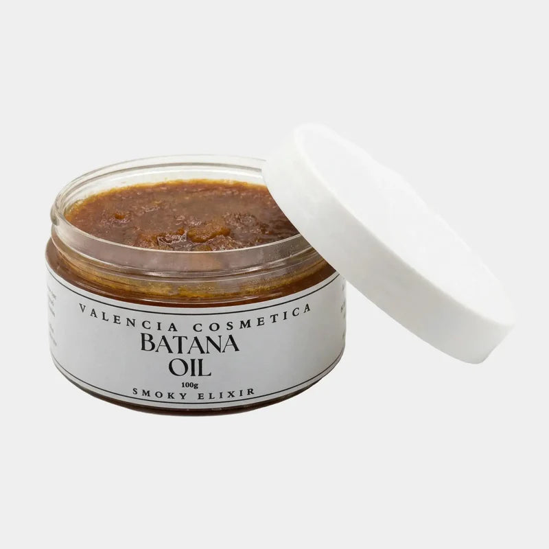 Batana Oil jar with open white lid, dark amber smoky balm inside